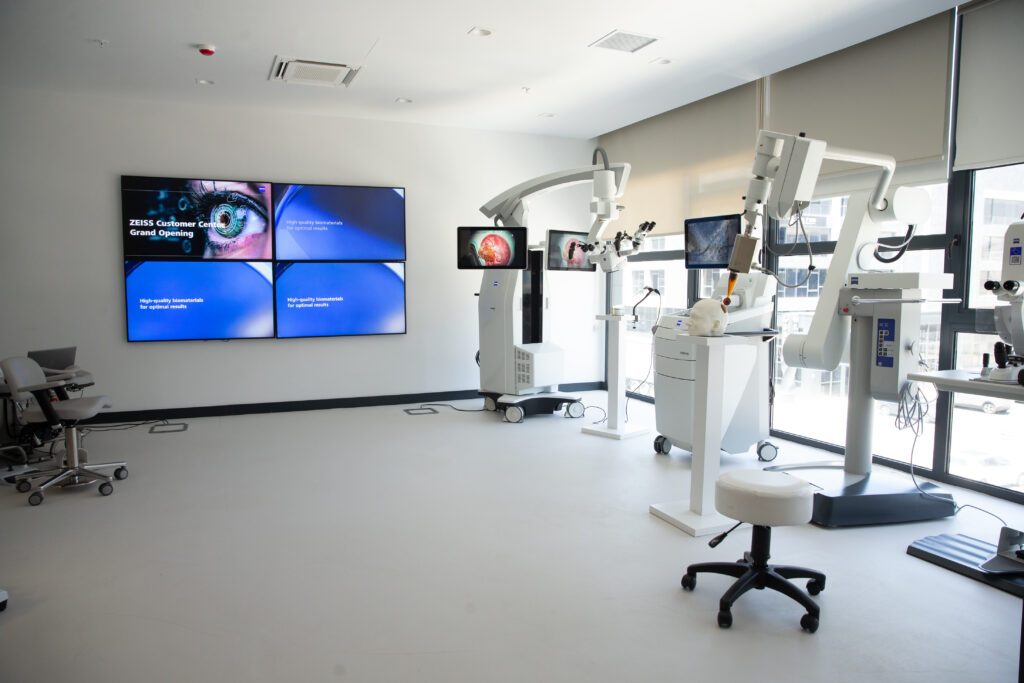 Medical technology demonstration room with a surgical microscope and video wall