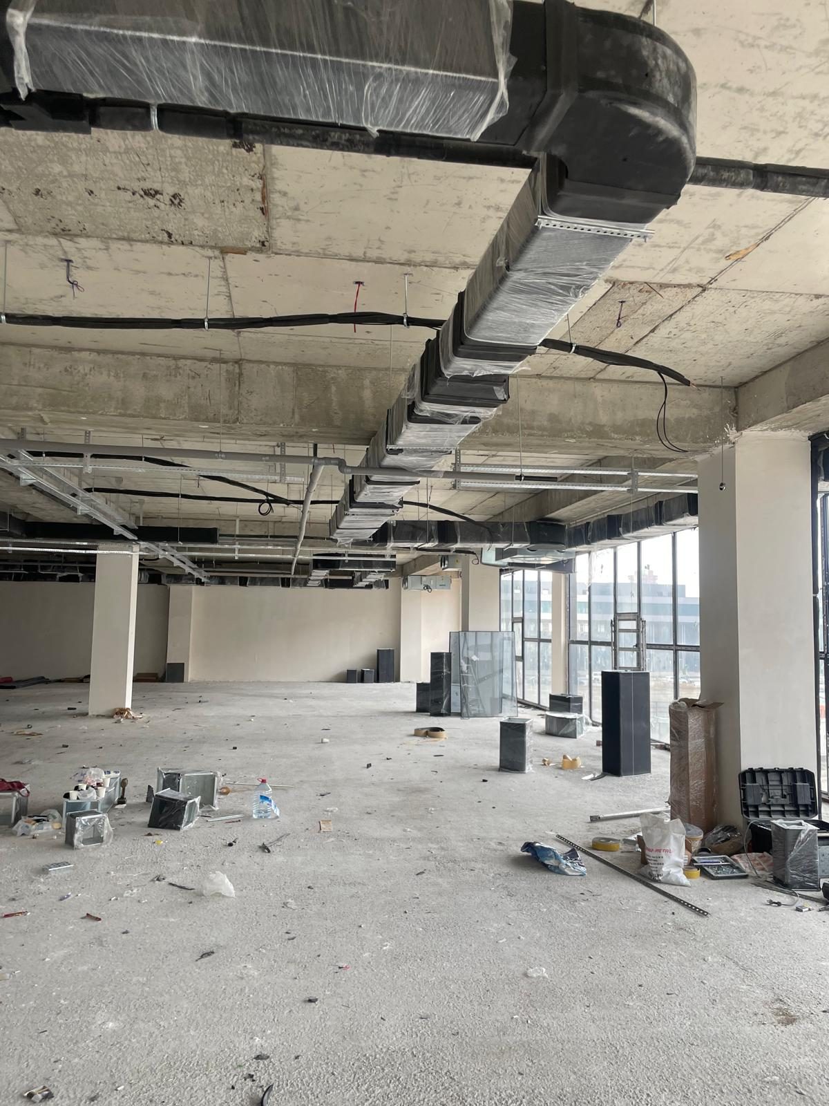 The rough concrete shell of the second floor in January 2025, columns and slab exposed, ductwork starting
