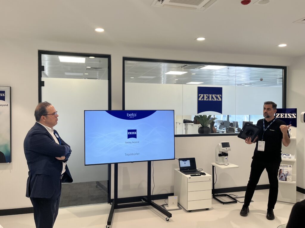 Two people presenting at a screen in the training area with the Zeiss reception behind